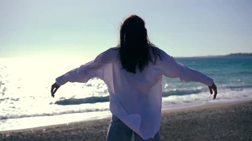 Slim Confident Young Woman Standing on Mediterranean Sea Beach at Sunset Raising Arms in Slow Motion