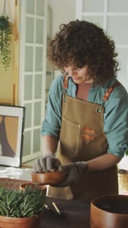 Person Planting Seeds at Wooden Table Indoors