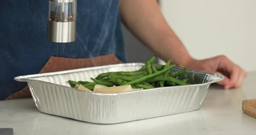 Chef Peppers Vegetables with an Electric Pepper Shaker Manual Grinder
