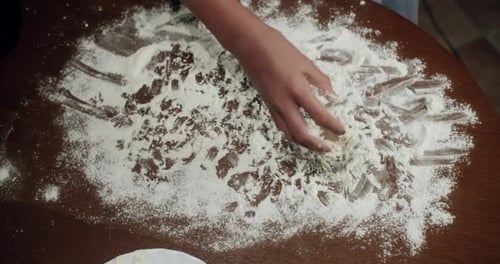 Child Prepares Dough on Floured Table