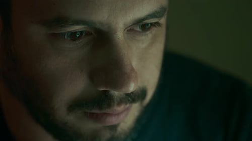 serious handsome man in the dark staring at camera