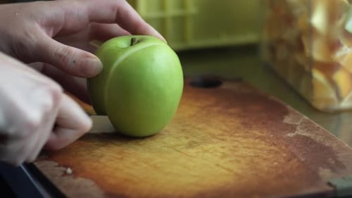 Chefkoch schneidet grünen Apfel an Bord im Restaurant
