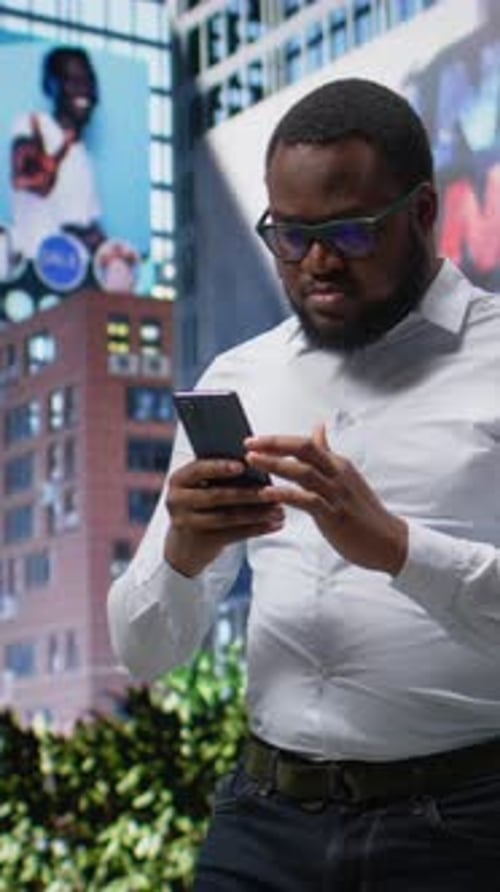 Vertical Video African American Male Opens Navigation on Phone Takes Downtown Walk