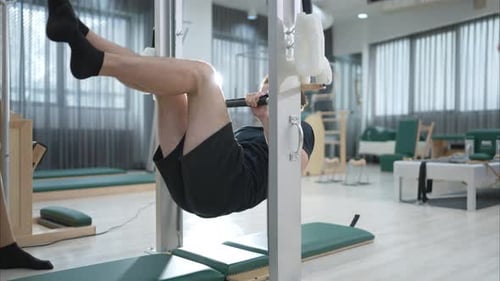Un joven y una mujer joven están haciendo ejercicios de pilates en un reformador de pilates