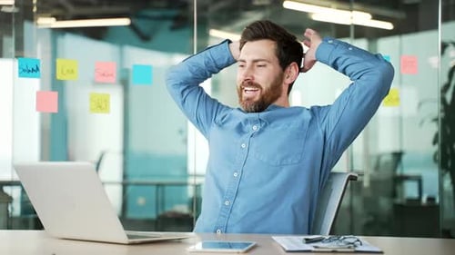 Successful Young Adult Celebrates at Office Desk