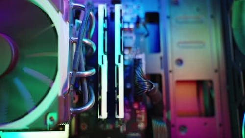 Dolly zoom, inside a gaming PC with rainbow lighting on the fans and components.