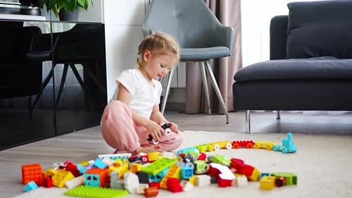 Little Girl Play with Constructor Toy on Floor in Home Educational Game Spending Leisure Activities