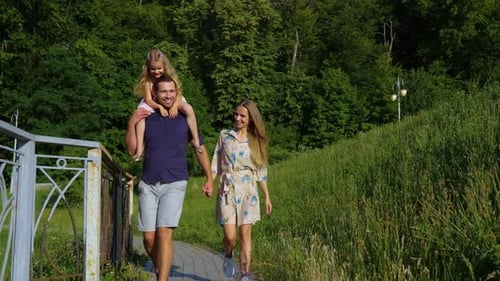 Cute Family with Little Child Walking in Park on Sunny Day Happy Family Holding Hands on a Walk with