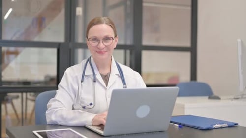 Senior Female Doctor Smiling at Camera in Office