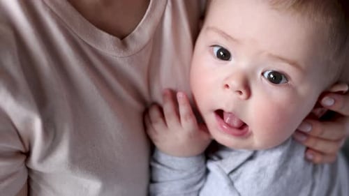 Adorable Infant Being Held in Loving Arms