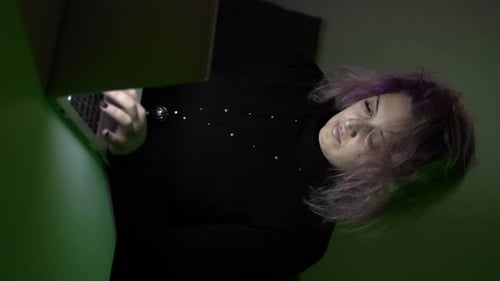 Woman working online from home at dark atmosphere. Concept of remote work
