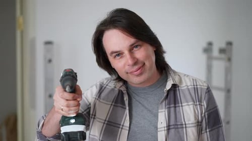 Adult Holding a Power Drill Indoors
