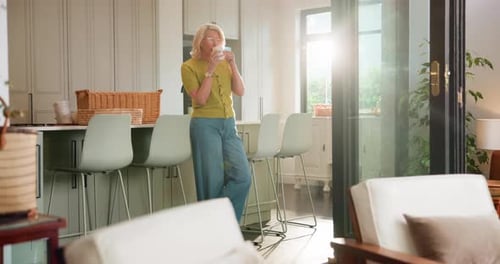 Woman Drinking Coffee Leaning on Kitchen Island Counter