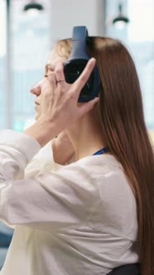 Woman Wearing Headphones Works on Computer at Office