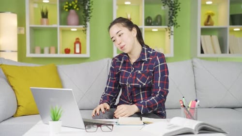 Woman Using Laptop and Smiling at Home