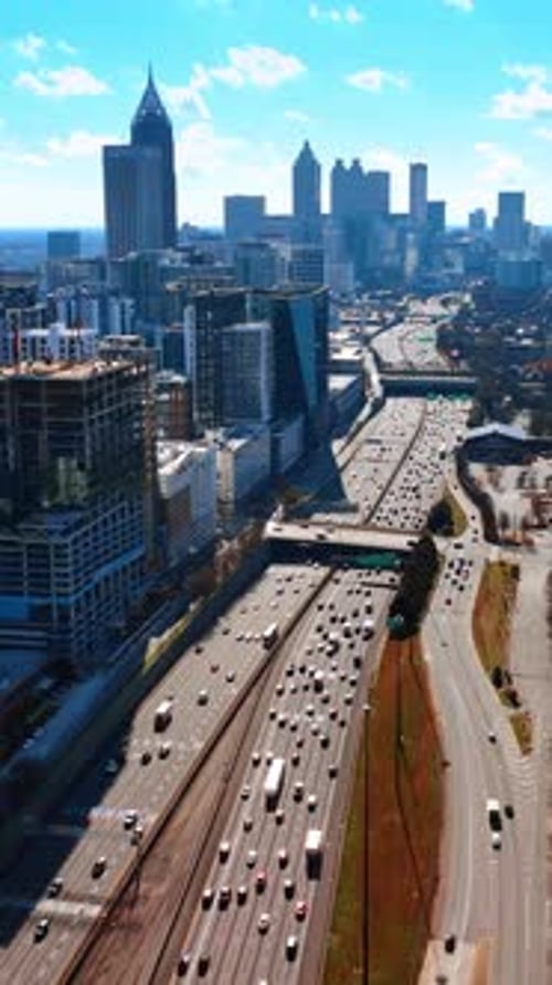 Sunny bright day in Atlanta, Georgia, USA. Drone footage of a cityscape over the busy highway.