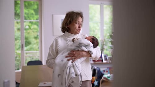 Woman Holds Newborn Infant in Bright Home Interior