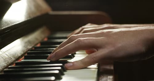 Hands Playing an Old Piano Keyboard