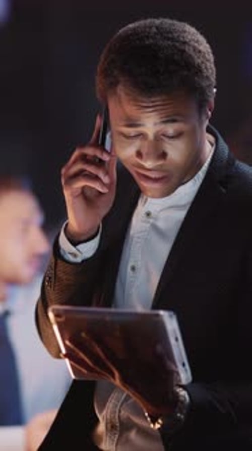 Adult Using Tablet and Talking on Cellphone