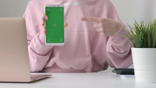 Woman Freelancer Shows Phone with Green Screen Mock Up Cellphone Telephone