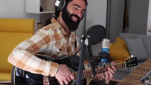 Man Playing Guitar and Singing at Home