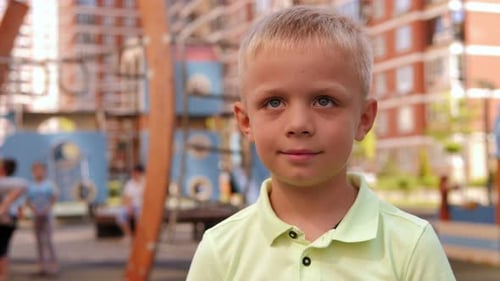 A Little Boy on the Playground in the Courtyard of a Modern Residential Complex