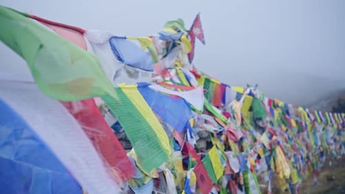 Buddhist Prayer Flags in Misty Mountains in Nepal, Colorful Tibetan Prayer Flags in Mist in the Hima