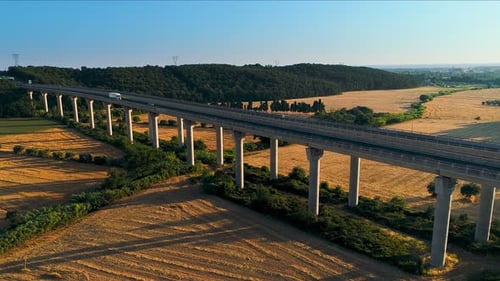 Aerial Shot of a White Truck with Cargo Load Pulling on the Massive Bridge with Traffic on it in th