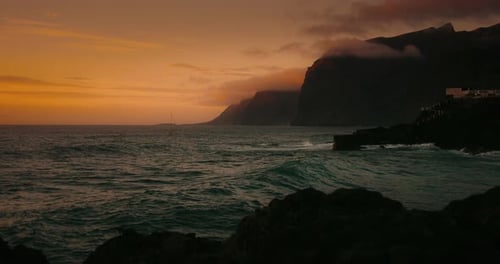 Rocky Beach Dark Ocean Water Waves at Summer Sunset Golden Hour Los Gigantes Cliffs and Gorgeous