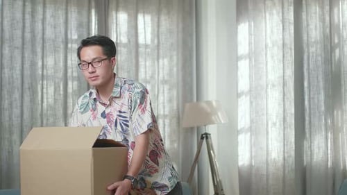 Man Carries Box Into Living Room