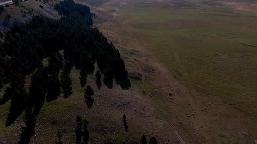 Camera moving over empty mountain road revealing valley
