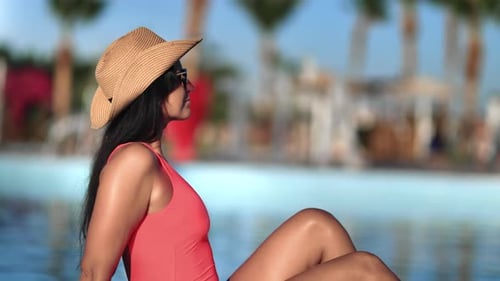 Beauty Brunette Female in Pink Bikini Sunglasses Resting at Swimming Pool Luxury Resort Hotel