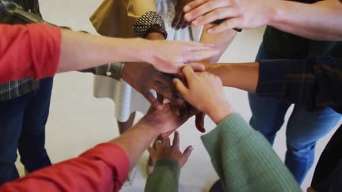 Diverse business people teaming up with hands together at office