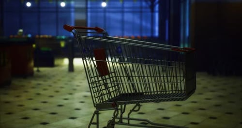 Shopping Cart Stands Alone in a Quiet Grocery Store at Night