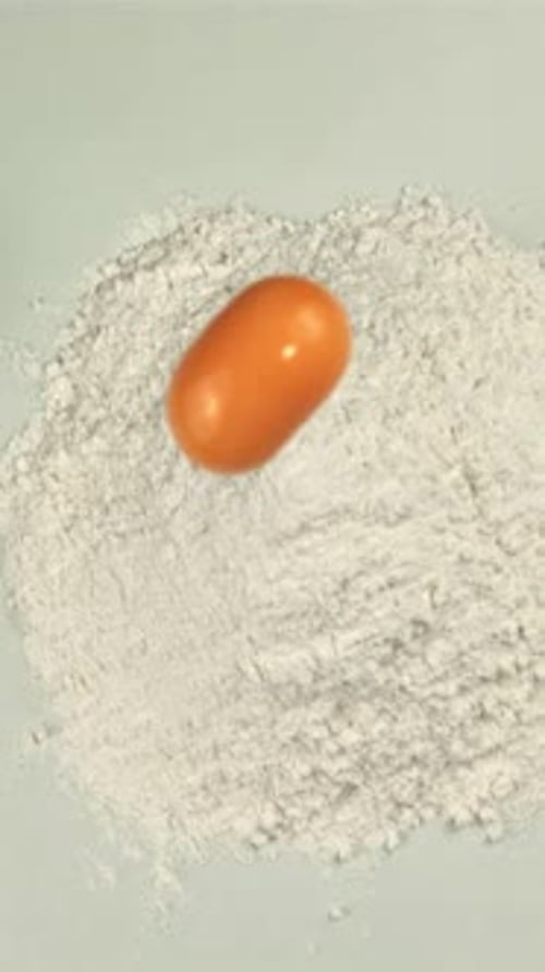 The Super Slow Motion of the Egg Falls Into a Pile of Flour on the Table with splashesFilmed on a