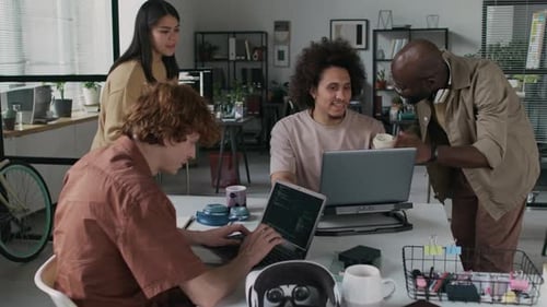 Four Software Developers Working on Collaborative Project in Corporate Office