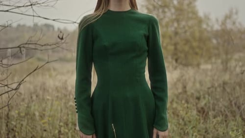 Model posing wearing green dress in autumn field