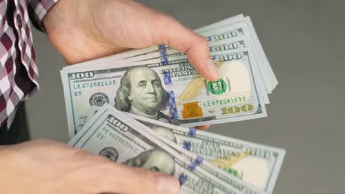 Counting One Hundred Dollar Bills in Hands