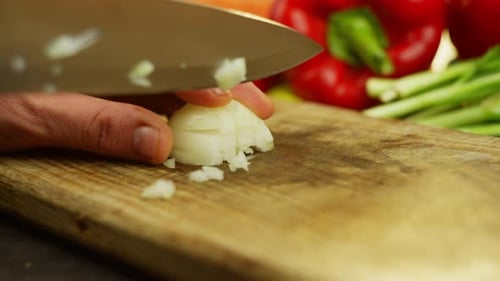 Chopping An Onion with a Knife on a Board