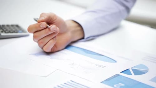 Business, People, Paperwork, Office and Technology Concept - Businessman Hands with Calculator