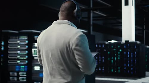 Software Developer in Data Center Workspace Coding on Tablet