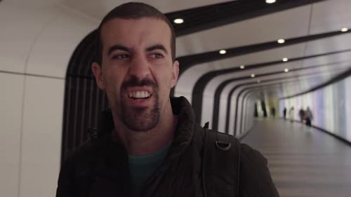 Man Walking Through Modern Urban Tunnel with Camera