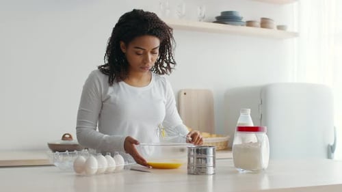 Woman Prepares Batter with Milk and Eggs