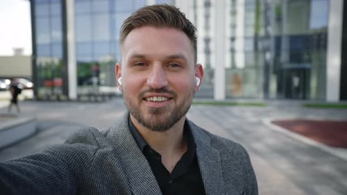Man Waving and Talking To Camera Outdoors