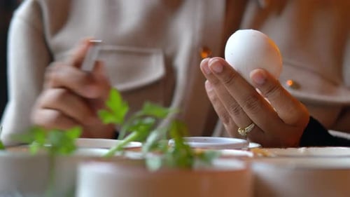 Woman Cutting Cooked Egg for Food Preparation