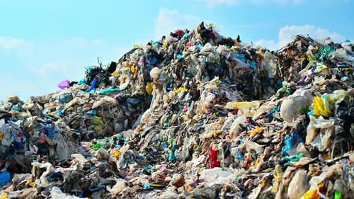 View of a huge heap of plastic garbage at waste sorting plant, flies around. Slow motion