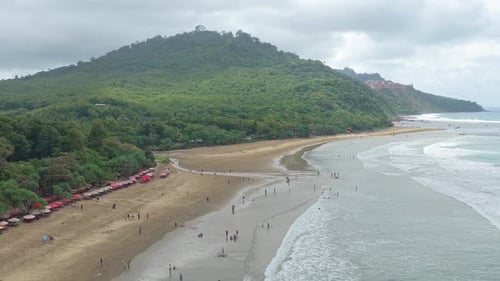 Menschen genießen an einem bewölkten Tag einen tropischen Strand in Java