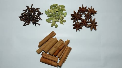 fresh raw cloves, cardamom, star anise and cinnamon stick in studio light shot on white background