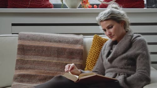 Dolly in einer jungen Frau, die studiert, ein Buch liest und Seiten durchblättert, während sie in ihrem Li lächelt