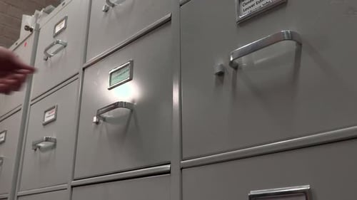 Office Worker Opening a File Cabinet in a File Storage Room.